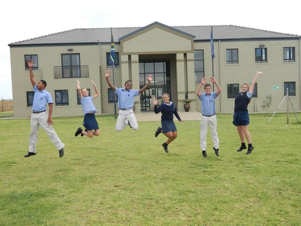 School children leaping into the air in front of Curro Bloemfontein