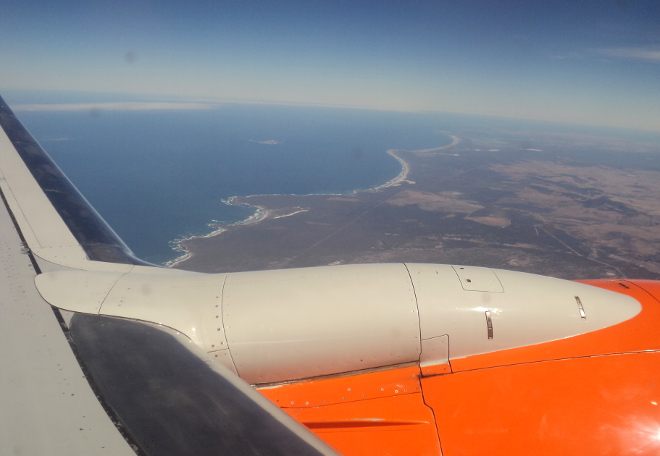 view over a Mango Airlines wing engine of the coastline north of Cape Town