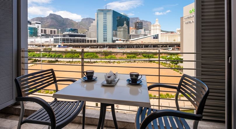 Coffee cups on table in the Harbour Bridge Hotel and Suites restaurant, with views of Cape Town city
