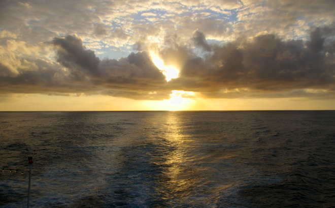 sunset below the clouds at sea