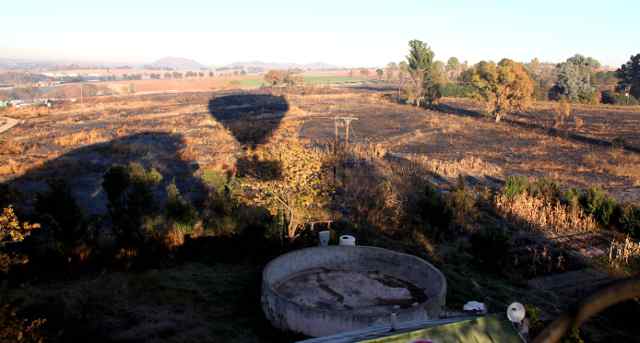 shadow of hot air balloon as it comes in to land